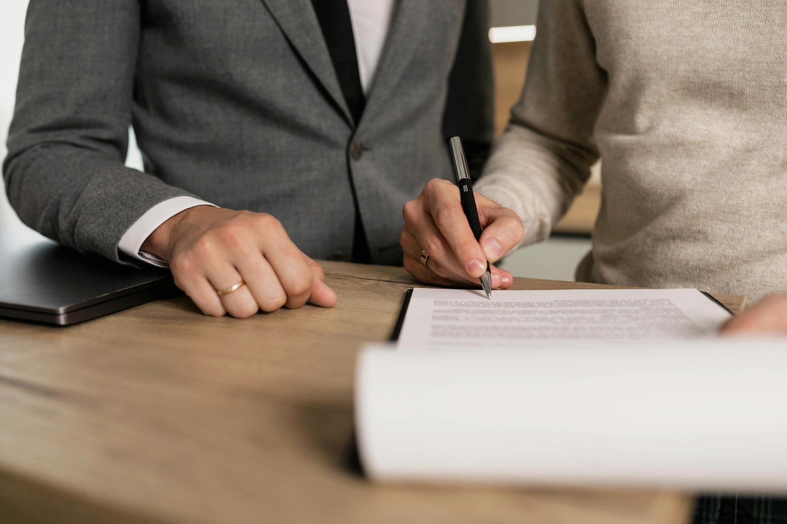 Close-up of businessmen signing able in an office.