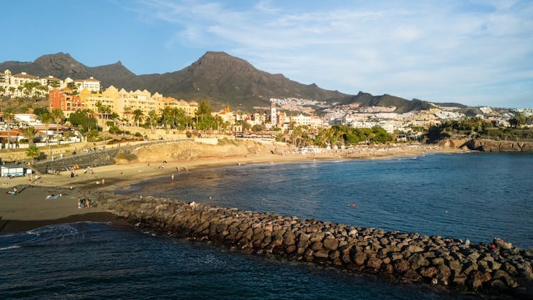 Scenic aerial view of Costa Adeje beach and town in Spain during sunset.