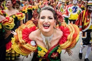 Smiling woman in colorful traditional attire at Carnival
