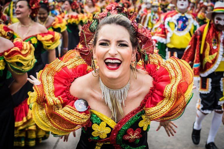 Smiling woman in colorful traditional attire at Carnival