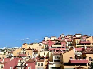 Colorful residential rooftops under clear blue sky in Costa Adeje, Spain, captured on a sunny day.