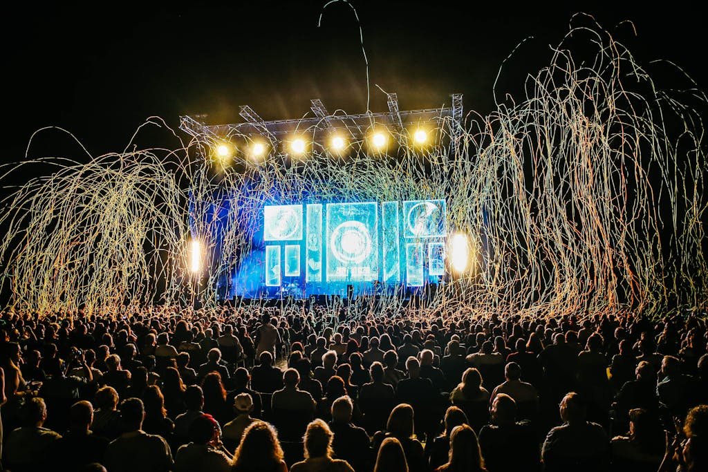 Dynamic live music concert with vibrant stage lights and a lively crowd enjoying the night.