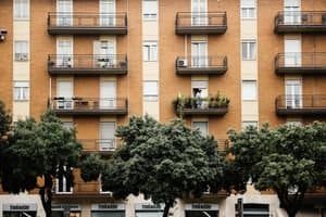 Multi-storey apartment building with balconies and lush greenery for an urban lifestyle.
