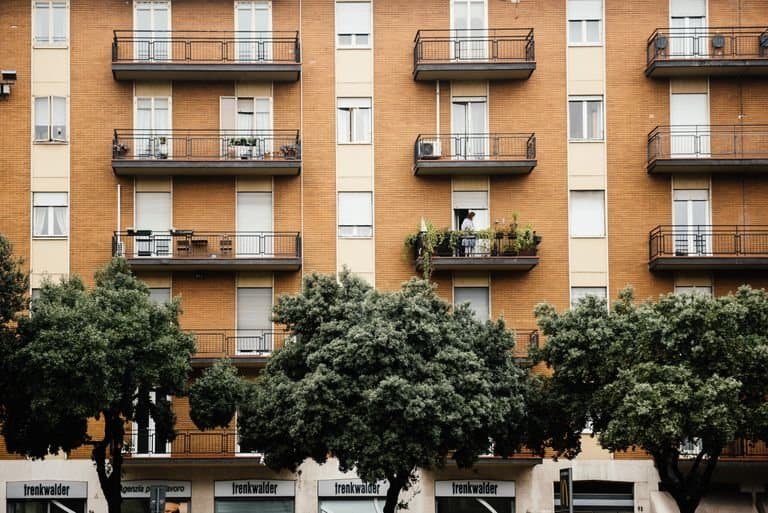 Multi-storey apartment building with balconies and lush greenery for an urban lifestyle.