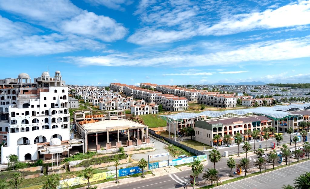 Aerial shot of a sprawling modern residential area under a bright blue sky.