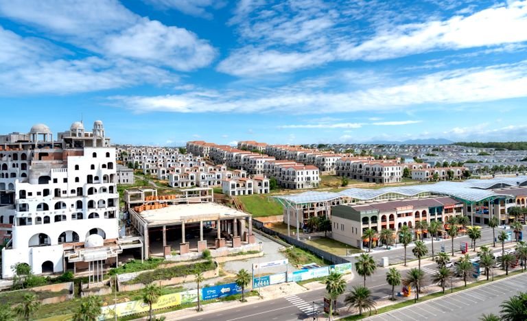 Aerial shot of a sprawling modern residential area under a bright blue sky.